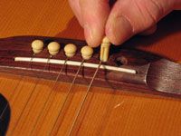 Cómo atar una cuerda de acero del puente de una guitarra acústica