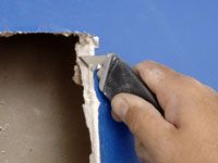 Cómo reparar agujeros grandes en paneles de yeso con un parche