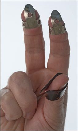 La posición correcta del toque de pulgar y fingerpicks. [Crédito: Fotografía por Anne Hamersky]